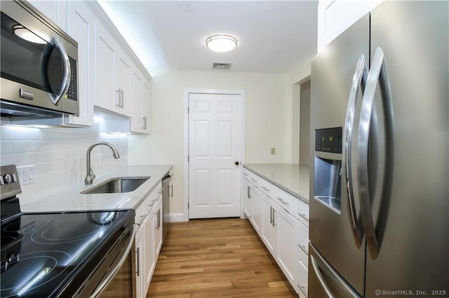 95 Audubon St Unit 339, New Haven, CT 06510 - kitchen featuring appliances with stainless steel finishes, light wood-style floors, white cabinets, and tasteful backsplash