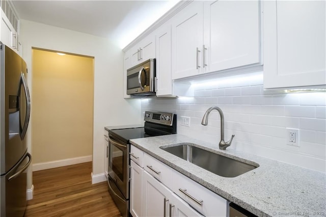 95 Audubon St Unit 339, New Haven, CT 06510 - kitchen featuring stainless steel appliances, white cabinetry, tasteful backsplash, wood finished floors, and light stone counters