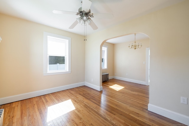 15 Magnolia Ave, Bristol, CT 06010 - unfurnished room featuring radiator, arched walkways, plenty of natural light, and light wood-type flooring
