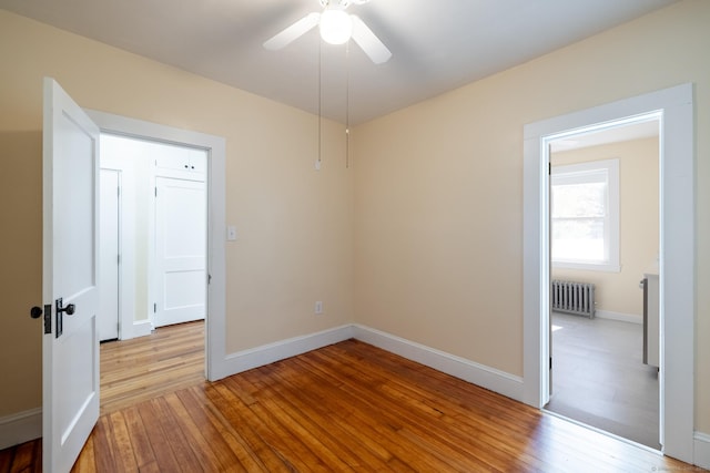 15 Magnolia Ave, Bristol, CT 06010 - unfurnished room with radiator heating unit, light wood-style flooring, and a ceiling fan