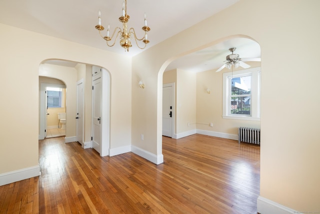 15 Magnolia Ave, Bristol, CT 06010 - spare room with radiator heating unit, arched walkways, light wood-type flooring, a ceiling fan, and a chandelier