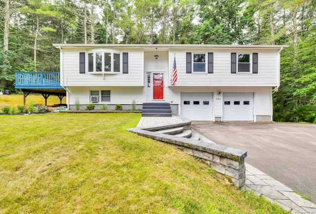 216 Old Monson Rd, Stafford, CT 06076 - split foyer home with driveway, an attached garage, a front yard, a wooden deck, and view of wooded area