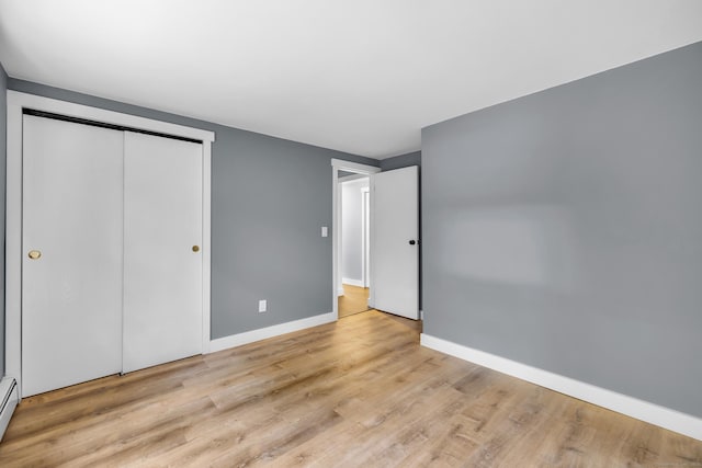 216 Old Monson Rd, Stafford, CT 06076 - unfurnished bedroom with wood finished floors, a closet, and a baseboard radiator