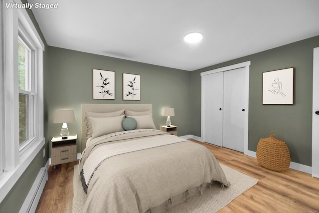 216 Old Monson Rd, Stafford, CT 06076 - bedroom featuring a baseboard heating unit, wood finished floors, and a closet