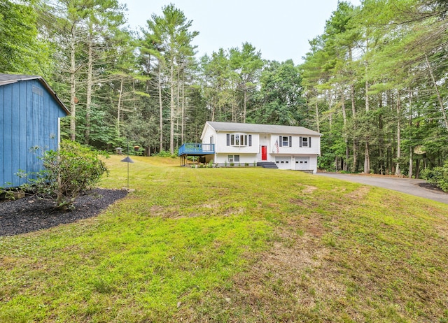 216 Old Monson Rd, Stafford, CT 06076 - split foyer home featuring an attached garage, driveway, a front yard, and a wooded view