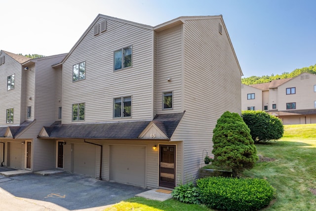 489 Wolcott St Unit 65, Bristol, CT 06010 - view of property with an attached garage, driveway, a front yard, and a shingled roof
