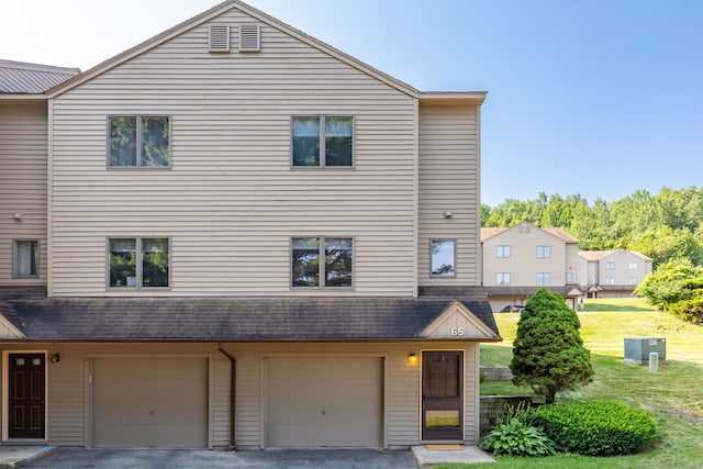489 Wolcott St Unit 65, Bristol, CT 06010 - view of property featuring a garage, a front lawn, and driveway