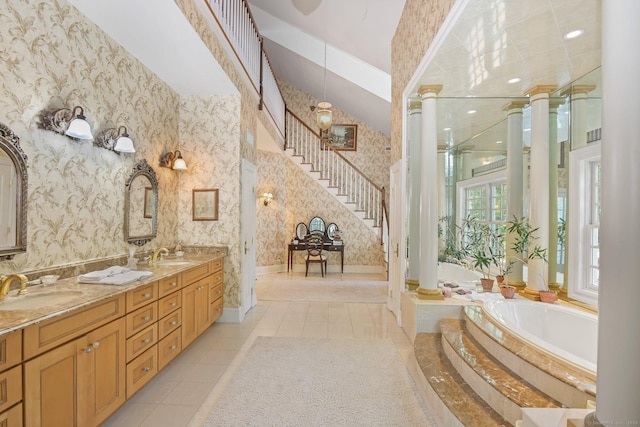63 Turney Rd, Redding, CT 06896 - bathroom with wallpapered walls, ornate columns, a bath, double vanity, and tile patterned flooring