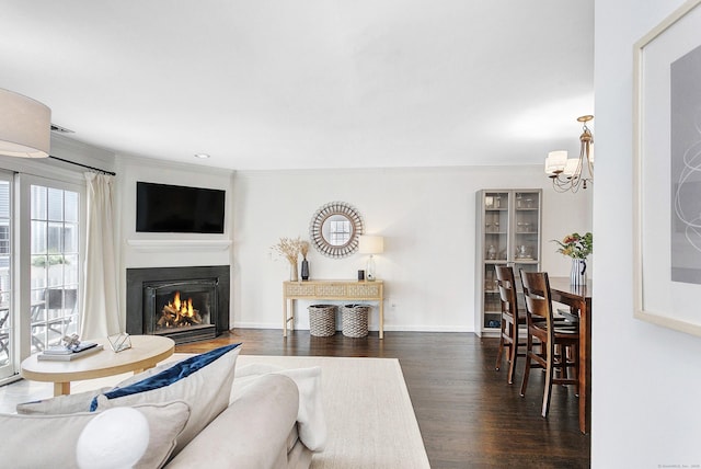 118 Grove St Apt 7, Stamford, CT 06901 - living room featuring a chandelier, dark wood-type flooring, crown molding, and a lit fireplace
