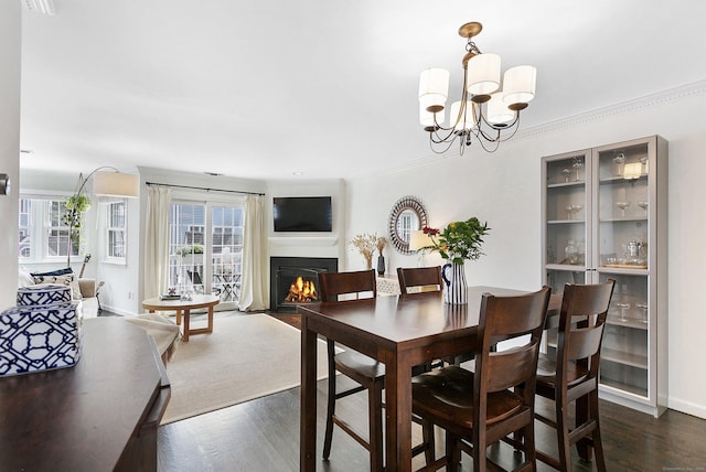 118 Grove St Apt 7, Stamford, CT 06901 - dining room with a fireplace with flush hearth, a chandelier, dark wood-style flooring, and crown molding