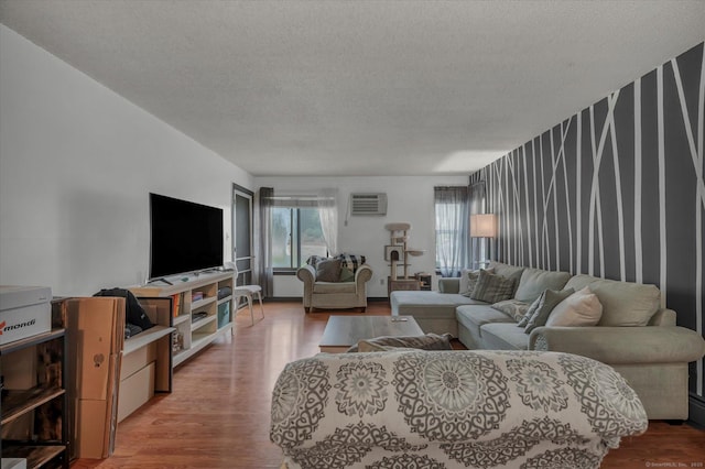 34 Woodland Dr Unit 34, Cromwell, CT 06416 - living room with light wood-type flooring, a textured ceiling, a wall mounted air conditioner, wallpapered walls, and an accent wall