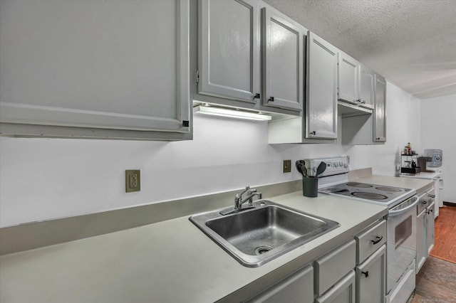 34 Woodland Dr Unit 34, Cromwell, CT 06416 - kitchen with white range with electric cooktop, a textured ceiling, light countertops, dark wood-style flooring, and gray cabinets