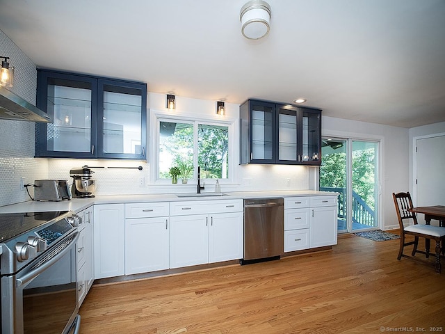481 Gaylord Mountain Rd, Hamden, CT 06518 - kitchen with stainless steel appliances, light wood-style floors, wall chimney range hood, light countertops, and glass insert cabinets