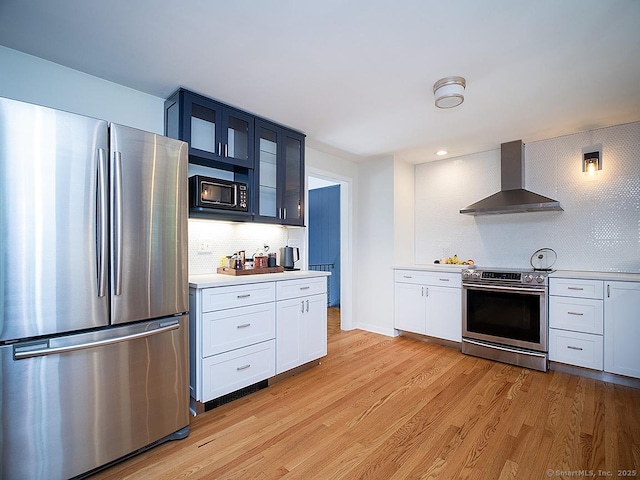 481 Gaylord Mountain Rd, Hamden, CT 06518 - kitchen featuring appliances with stainless steel finishes, wall chimney exhaust hood, light countertops, glass insert cabinets, and tasteful backsplash