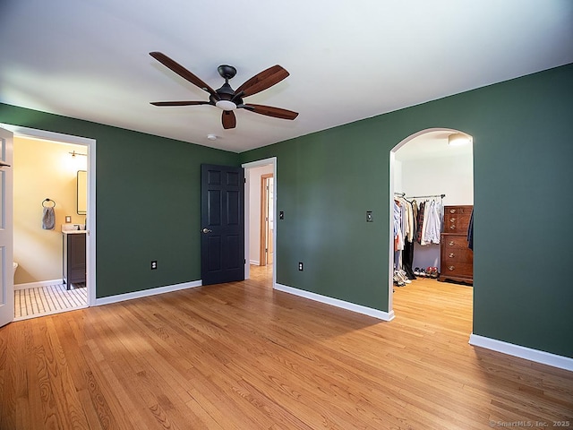 481 Gaylord Mountain Rd, Hamden, CT 06518 - unfurnished bedroom with arched walkways, light wood-style flooring, a walk in closet, and connected bathroom