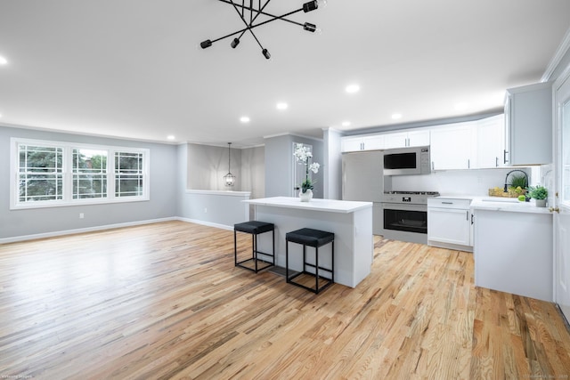 107 Meetinghouse Rdg, Meriden, CT 06450 - kitchen featuring white microwave, a kitchen island, oven, light wood-style flooring, and crown molding