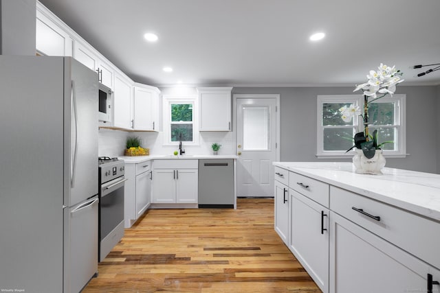 107 Meetinghouse Rdg, Meriden, CT 06450 - kitchen featuring appliances with stainless steel finishes, light wood-style floors, white cabinetry, recessed lighting, and backsplash
