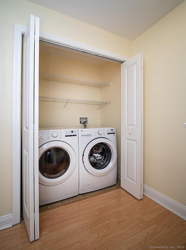 128 Briar Ln Unit 128, Norwich, CT 06360 - washroom with washing machine and clothes dryer and light wood-style floors