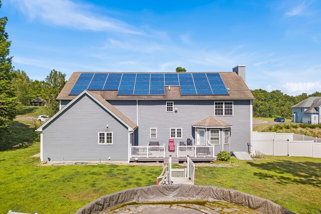 5 Evas Ter, Wolcott, CT 06716 - back of house with a deck, roof mounted solar panels, a chimney, and roof with shingles