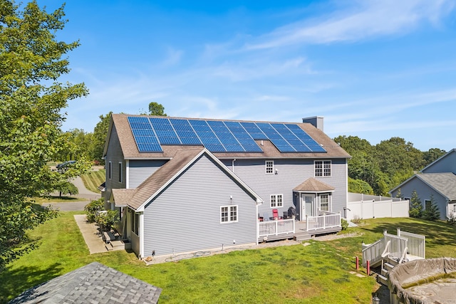 5 Evas Ter, Wolcott, CT 06716 - back of property featuring a deck, roof mounted solar panels, a chimney, and roof with shingles