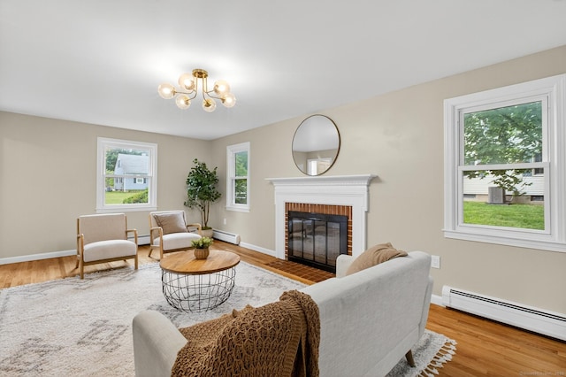 29 Bradford Dr, Windsor, CT 06095 - living room featuring a baseboard radiator, a brick fireplace, a chandelier, and wood finished floors