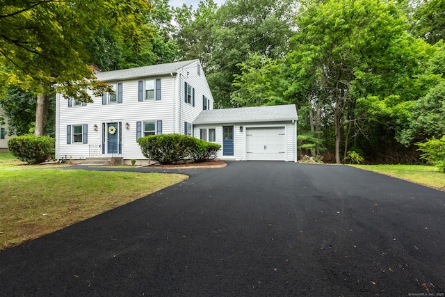 29 Bradford Dr, Windsor, CT 06095 - colonial house featuring a garage, asphalt driveway, a front lawn, and view of scattered trees