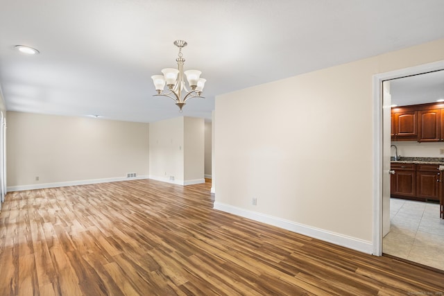 253 Simsbury Rd, West Hartford, CT 06117 - unfurnished room featuring light wood finished floors and a chandelier
