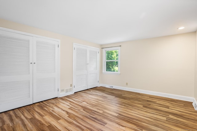 253 Simsbury Rd, West Hartford, CT 06117 - unfurnished bedroom with multiple closets, light wood-style floors, and recessed lighting