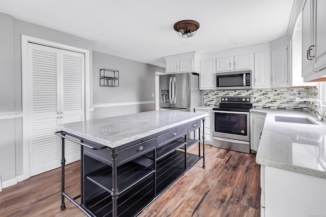 66 Bridgeport Ave, Bristol, CT 06010 - kitchen with appliances with stainless steel finishes, backsplash, white cabinetry, dark wood-style flooring, and light stone countertops