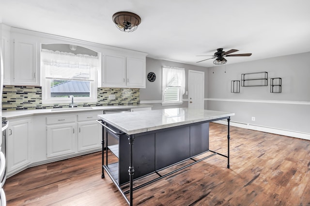 66 Bridgeport Ave, Bristol, CT 06010 - kitchen featuring ceiling fan, decorative backsplash, white cabinets, and a breakfast bar area