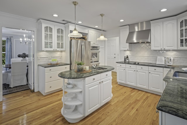 70 Fitch Ln, New Canaan, CT 06840 - kitchen featuring wall chimney exhaust hood, appliances with stainless steel finishes, backsplash, open shelves, and white cabinetry