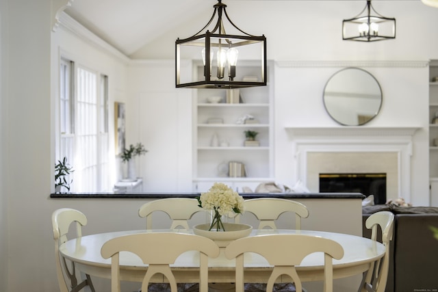 70 Fitch Ln, New Canaan, CT 06840 - dining area featuring a chandelier, vaulted ceiling, and a glass covered fireplace