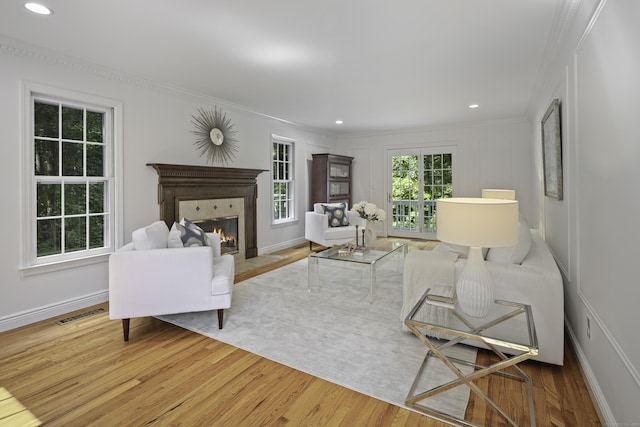 70 Fitch Ln, New Canaan, CT 06840 - living area with wood finished floors, crown molding, a glass covered fireplace, a decorative wall, and recessed lighting