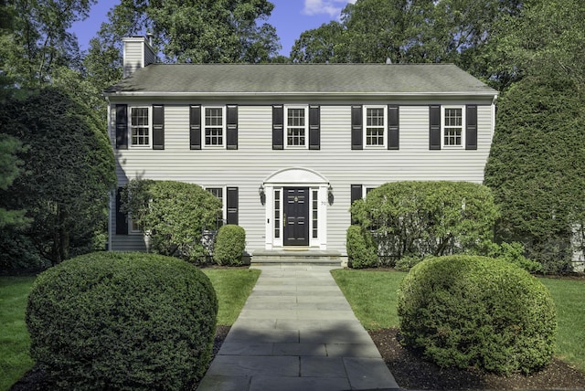 70 Fitch Ln, New Canaan, CT 06840 - colonial-style house with a chimney, a front yard, and roof with shingles