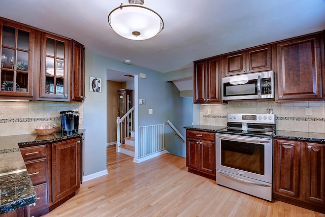 16 Kenwood Rd, Meriden, CT 06450 - kitchen featuring stainless steel appliances, light wood finished floors, tasteful backsplash, glass insert cabinets, and dark stone counters