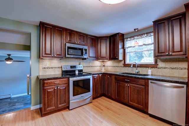 16 Kenwood Rd, Meriden, CT 06450 - kitchen featuring appliances with stainless steel finishes, light wood-style floors, dark stone countertops, tasteful backsplash, and ceiling fan