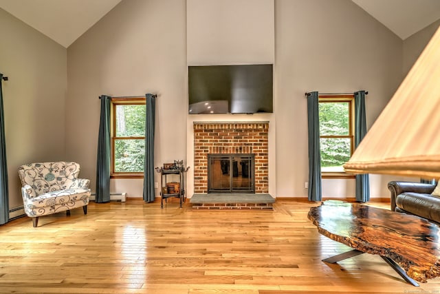 330 Webb Cir, Monroe, CT 06468 - living area with high vaulted ceiling, light wood-style floors, a brick fireplace, and baseboard heating