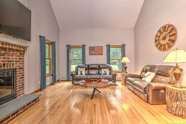 330 Webb Cir, Monroe, CT 06468 - living room featuring high vaulted ceiling, light wood-style floors, a fireplace, and a baseboard heating unit