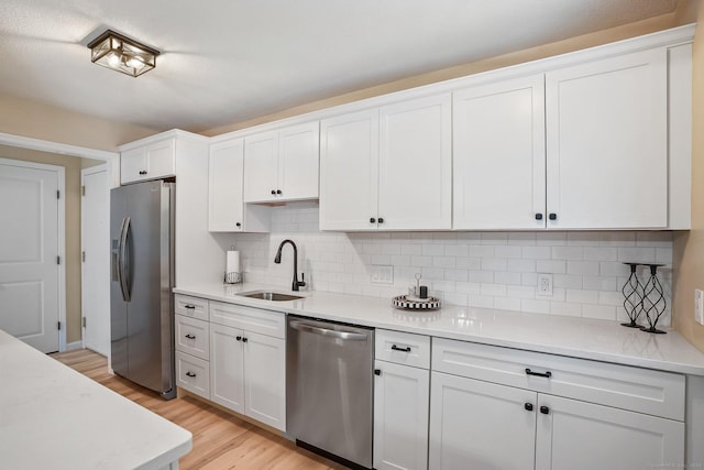 499 Heritage Vlg Unit B, Southbury, CT 06488 - kitchen with appliances with stainless steel finishes, light wood finished floors, light countertops, white cabinets, and tasteful backsplash