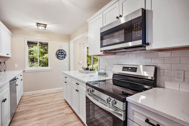499 Heritage Vlg Unit B, Southbury, CT 06488 - kitchen featuring stainless steel appliances, decorative backsplash, and white cabinetry