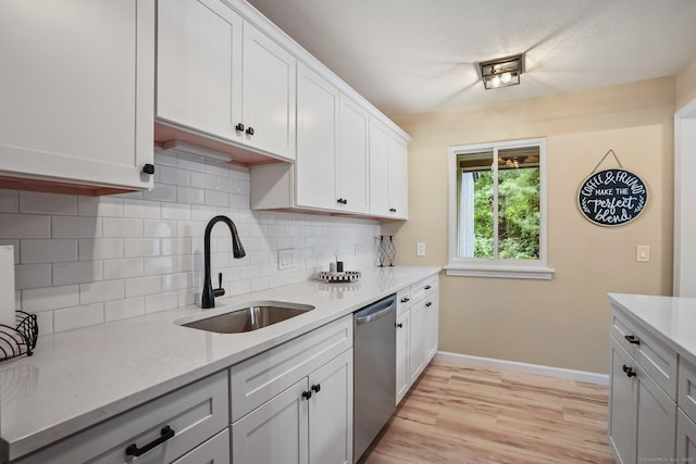 499 Heritage Vlg Unit B, Southbury, CT 06488 - kitchen with stainless steel dishwasher, decorative backsplash, light wood-type flooring, white cabinets, and light stone countertops