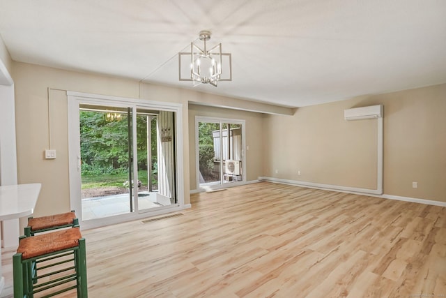 499 Heritage Vlg Unit B, Southbury, CT 06488 - unfurnished living room featuring a chandelier, an AC wall unit, and wood finished floors