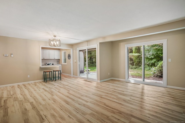 499 Heritage Vlg Unit B, Southbury, CT 06488 - unfurnished living room with a chandelier and light wood-type flooring