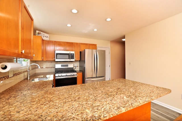 19 Windy Hill Ln Unit 19, Rocky Hill, CT 06067 - kitchen with appliances with stainless steel finishes, recessed lighting, wood finished floors, a peninsula, and light stone counters