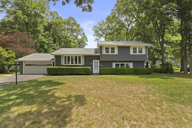 66 Oakwood Dr, North Haven, CT 06473 - split level home featuring concrete driveway, a garage, a front yard, and a chimney
