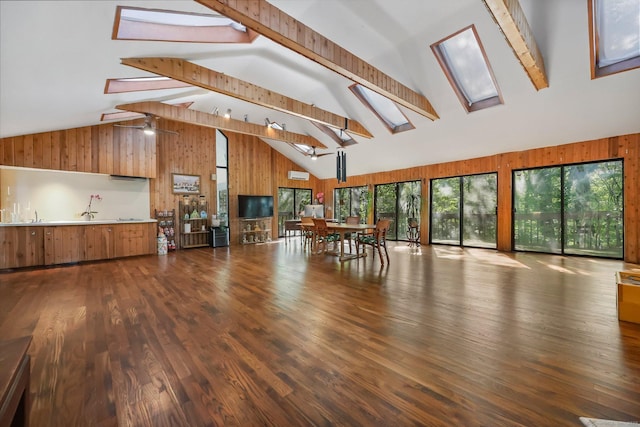 22 Blackberry Dr E, Stamford, CT 06903 - unfurnished living room featuring a skylight, wood walls, beam ceiling, high vaulted ceiling, and dark wood finished floors