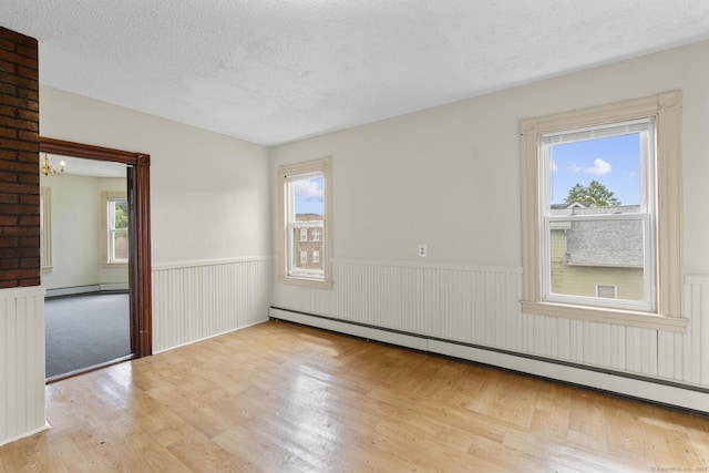240 Washington St, New Britain, CT 06051 - empty room with a wainscoted wall, a baseboard radiator, wood finished floors, a baseboard heating unit, and a textured ceiling