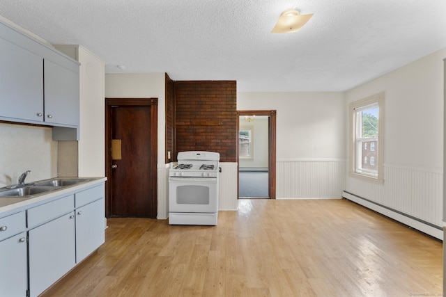 240 Washington St, New Britain, CT 06051 - kitchen with white gas range, baseboard heating, light wood-style flooring, wainscoting, and a textured ceiling