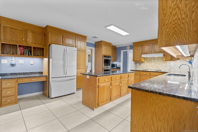 28 Fieldstone Path, Newington, CT 06111 - kitchen with freestanding refrigerator, dark stone counters, a center island, built in study area, and decorative backsplash