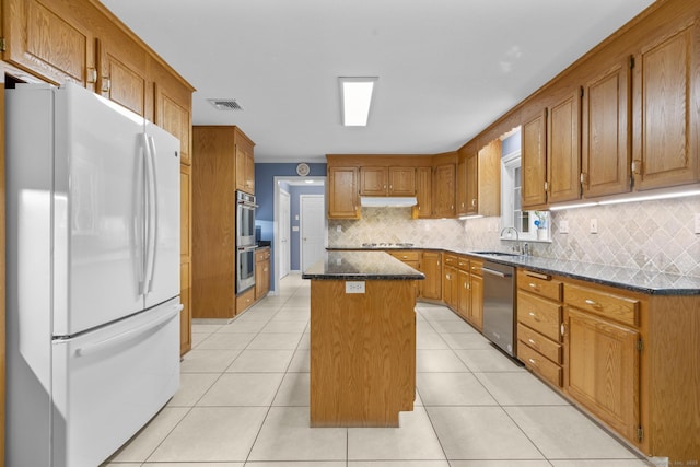28 Fieldstone Path, Newington, CT 06111 - kitchen featuring stainless steel appliances, a center island, backsplash, brown cabinets, and dark stone counters